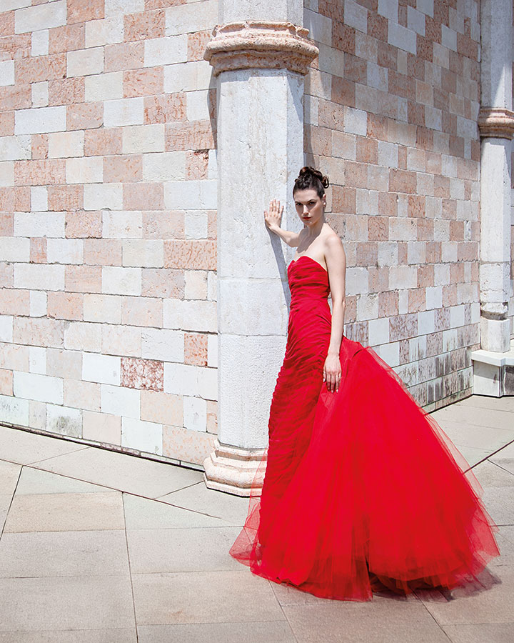 Abito rosso haute couture fotografato nella cornice della Basilica Palladiana di Vicenza